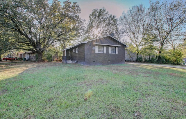 property exterior at dusk featuring a yard