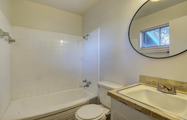 full bathroom featuring vanity, tiled shower / bath combo, and toilet