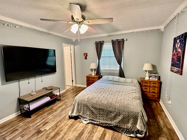 bedroom with hardwood / wood-style flooring, ceiling fan, a textured ceiling, and crown molding