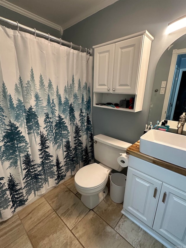 bathroom with toilet, walk in shower, vanity, and crown molding