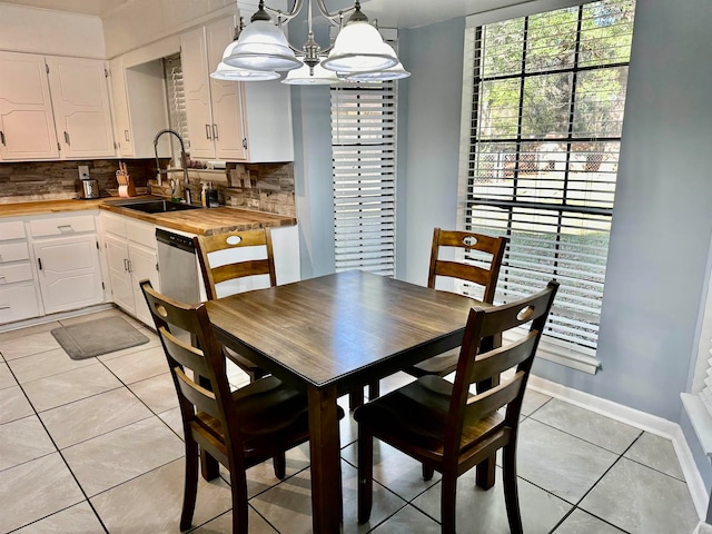 tiled dining space featuring sink and a notable chandelier