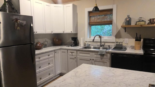 kitchen with white cabinets, dishwasher, sink, and stainless steel refrigerator