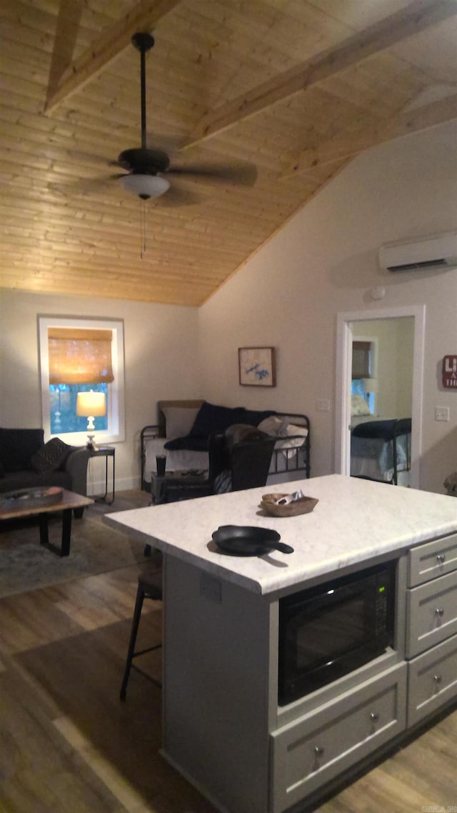 kitchen with black microwave, ceiling fan, wooden ceiling, vaulted ceiling with beams, and light hardwood / wood-style floors