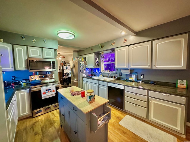 kitchen featuring beamed ceiling, white cabinetry, appliances with stainless steel finishes, light wood-type flooring, and butcher block countertops