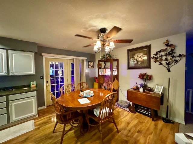 dining area with light wood-type flooring and ceiling fan