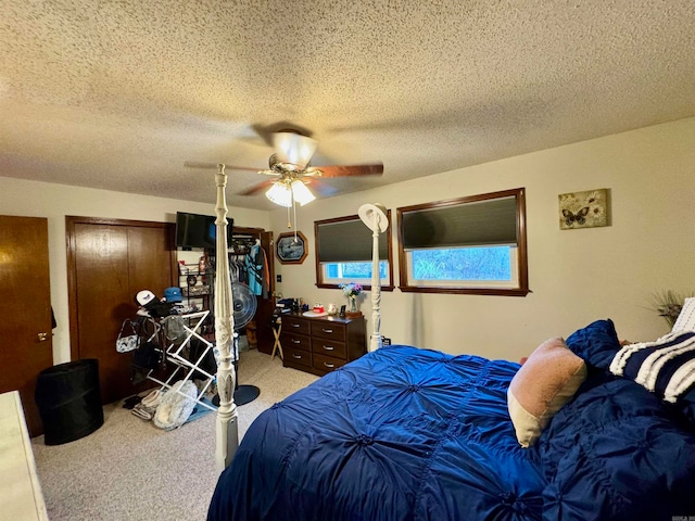 bedroom with ceiling fan, a textured ceiling, and light colored carpet