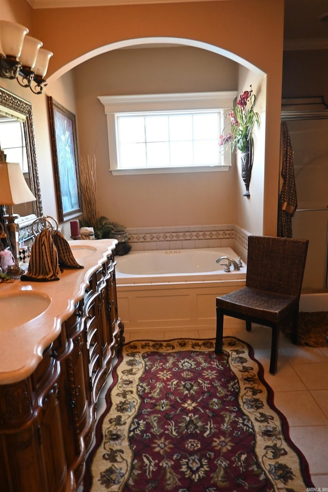 bathroom featuring vanity, a tub, tile patterned floors, and a healthy amount of sunlight