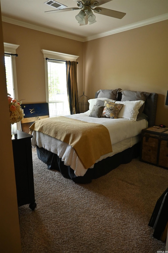 carpeted bedroom with ornamental molding and ceiling fan