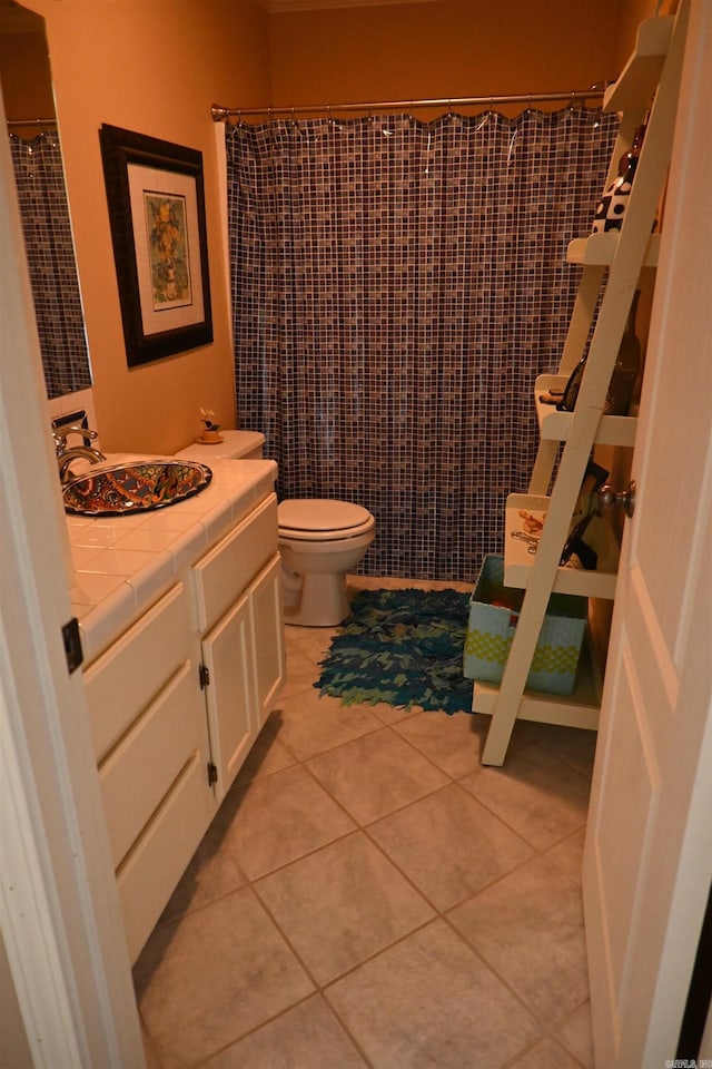 bathroom featuring toilet, vanity, tile patterned floors, and curtained shower