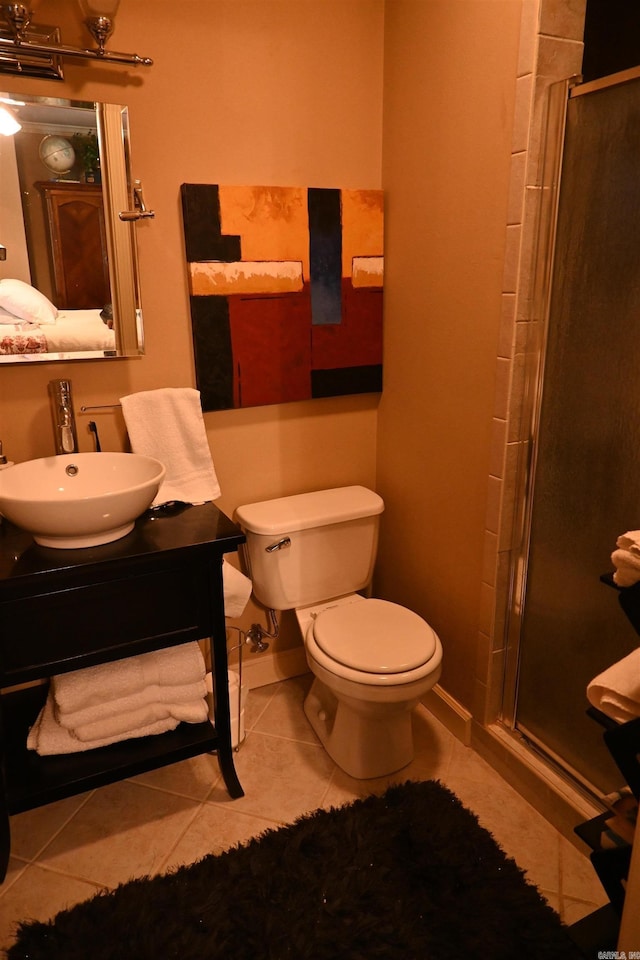 bathroom featuring toilet, sink, tile patterned flooring, and a shower with door