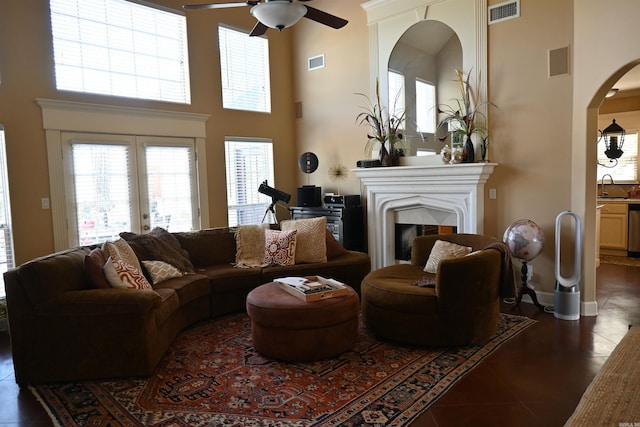 tiled living room with a high ceiling, sink, and ceiling fan