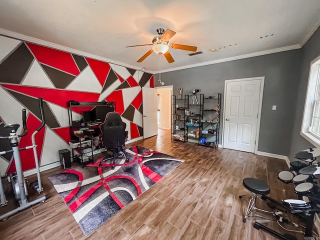 exercise area featuring ceiling fan, wood-type flooring, and crown molding