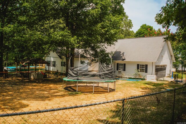 back of house with a trampoline