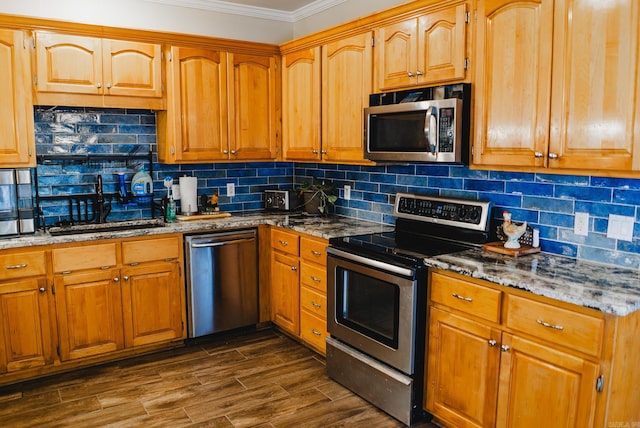 kitchen with stainless steel appliances, dark wood-type flooring, tasteful backsplash, ornamental molding, and light stone countertops