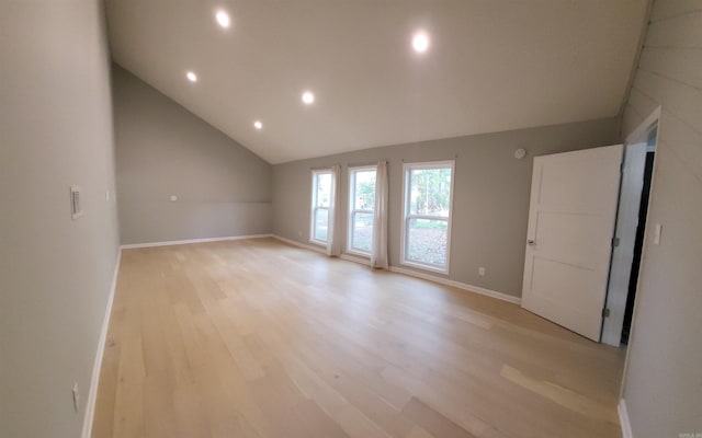 spare room with light hardwood / wood-style flooring and vaulted ceiling