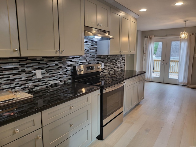 kitchen with dark stone counters, gray cabinetry, light hardwood / wood-style floors, and electric range