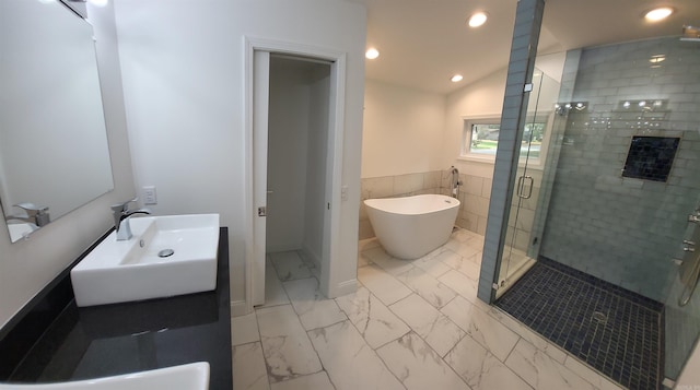 bathroom featuring tile walls, vanity, shower with separate bathtub, and lofted ceiling