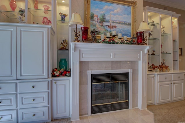 living room featuring a tile fireplace, light carpet, and crown molding