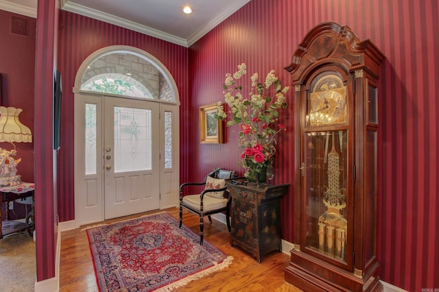 entrance foyer featuring hardwood / wood-style floors and crown molding