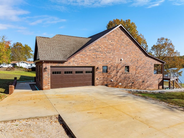 view of side of home with a garage and a lawn