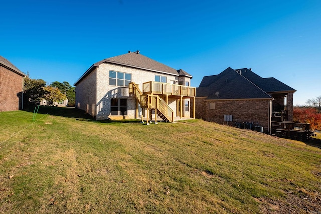 rear view of house featuring a lawn and a wooden deck