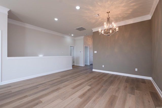 empty room featuring light hardwood / wood-style flooring, ornamental molding, and an inviting chandelier