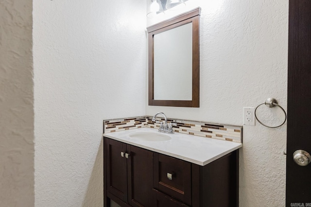 bathroom featuring vanity and tasteful backsplash