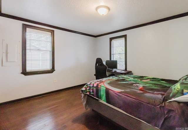 bedroom with a textured ceiling, electric panel, wood-type flooring, and multiple windows