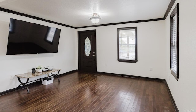 foyer entrance featuring dark hardwood / wood-style flooring, a textured ceiling, and crown molding