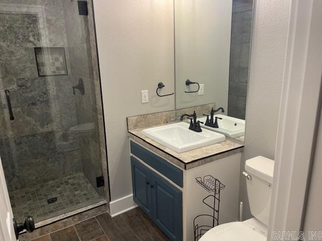 bathroom with walk in shower, wood-type flooring, vanity, and toilet