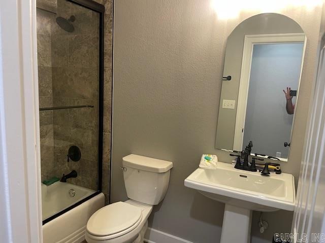 bathroom featuring toilet and combined bath / shower with glass door