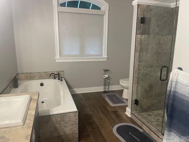 bathroom with toilet, hardwood / wood-style flooring, and separate shower and tub