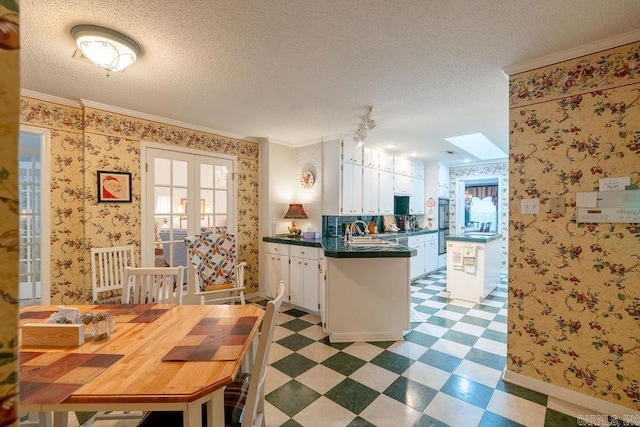 kitchen featuring kitchen peninsula, french doors, white cabinets, and ornamental molding