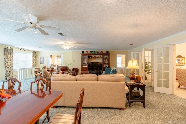 living room with plenty of natural light, ceiling fan, and a textured ceiling