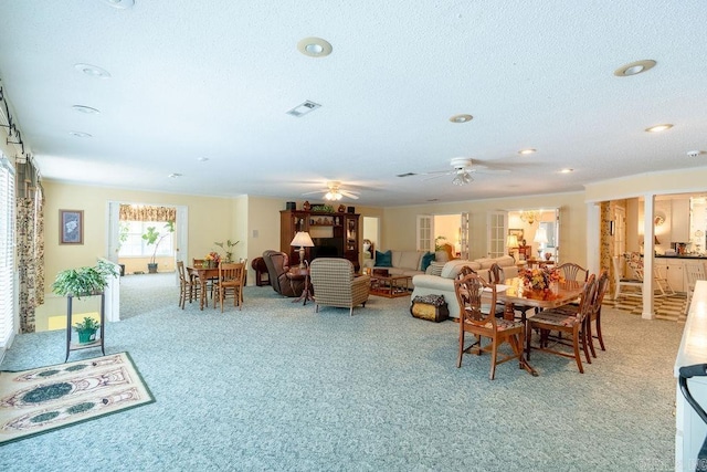 carpeted dining area with ceiling fan and a textured ceiling