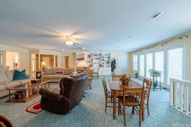 dining space featuring carpet flooring, ceiling fan, and a textured ceiling