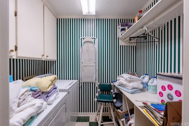 laundry area with cabinets, independent washer and dryer, and a textured ceiling