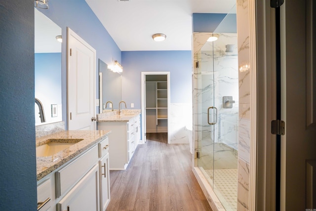 bathroom with vanity, hardwood / wood-style flooring, and a shower with door