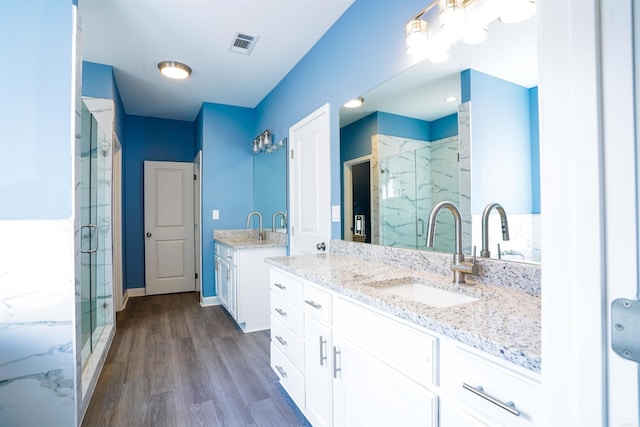 bathroom with walk in shower, vanity, and hardwood / wood-style flooring