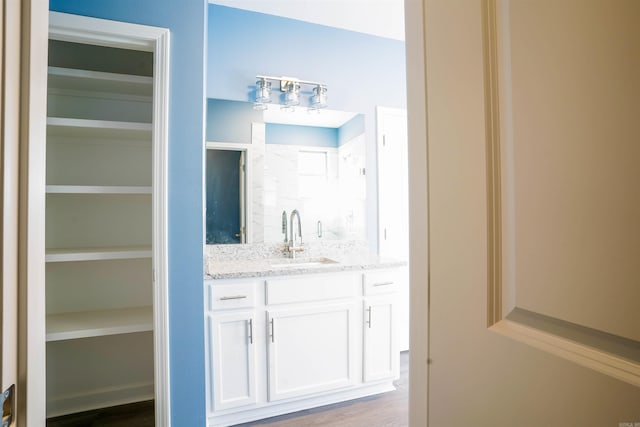 bathroom featuring a shower, vanity, and hardwood / wood-style flooring