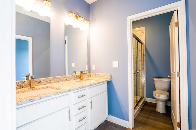 bathroom featuring hardwood / wood-style floors, an enclosed shower, vanity, and toilet