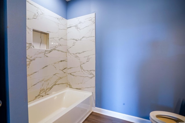 bathroom featuring a bathtub, toilet, and wood-type flooring