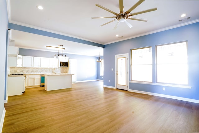 unfurnished living room featuring ceiling fan with notable chandelier, light hardwood / wood-style flooring, and ornamental molding