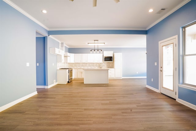 kitchen with white cabinetry, pendant lighting, decorative backsplash, stainless steel range, and light hardwood / wood-style flooring