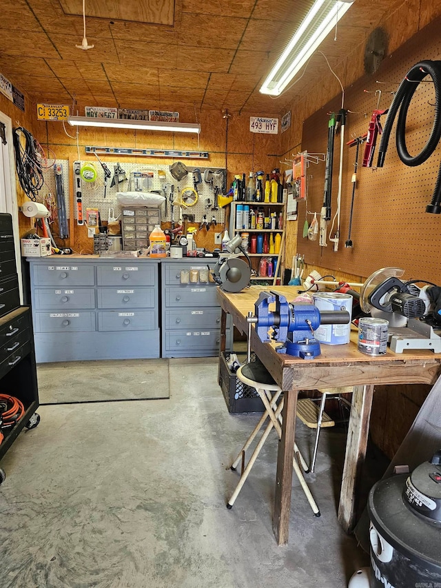 miscellaneous room featuring concrete flooring and a workshop area