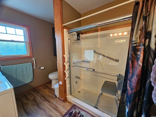 bathroom featuring toilet, hardwood / wood-style flooring, and a shower with door