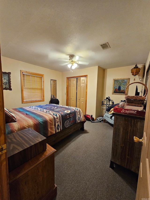 carpeted bedroom with ceiling fan, a textured ceiling, and a closet