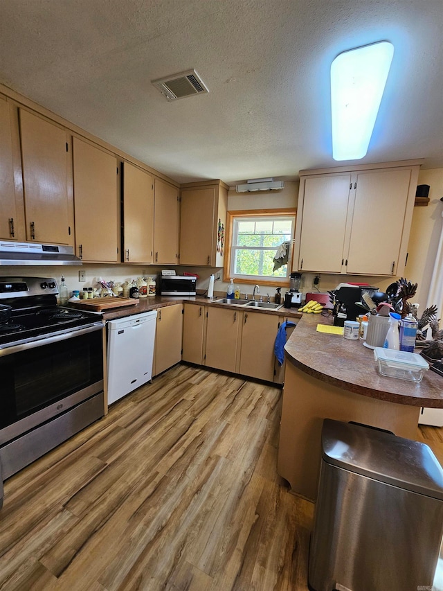 kitchen featuring kitchen peninsula, white dishwasher, a textured ceiling, light hardwood / wood-style flooring, and electric stove