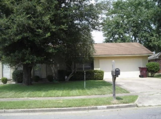 3202 Kendyl, Pine Bluff, AR 71603 - view of front of house featuring a front lawn, concrete driveway, and stucco siding