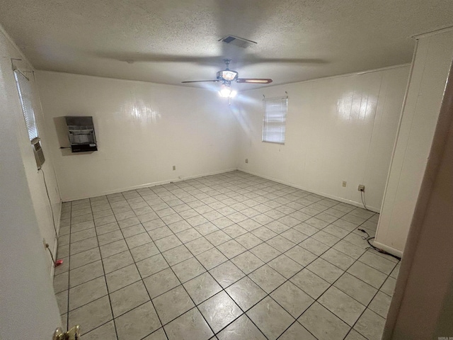 tiled spare room featuring a textured ceiling and ceiling fan